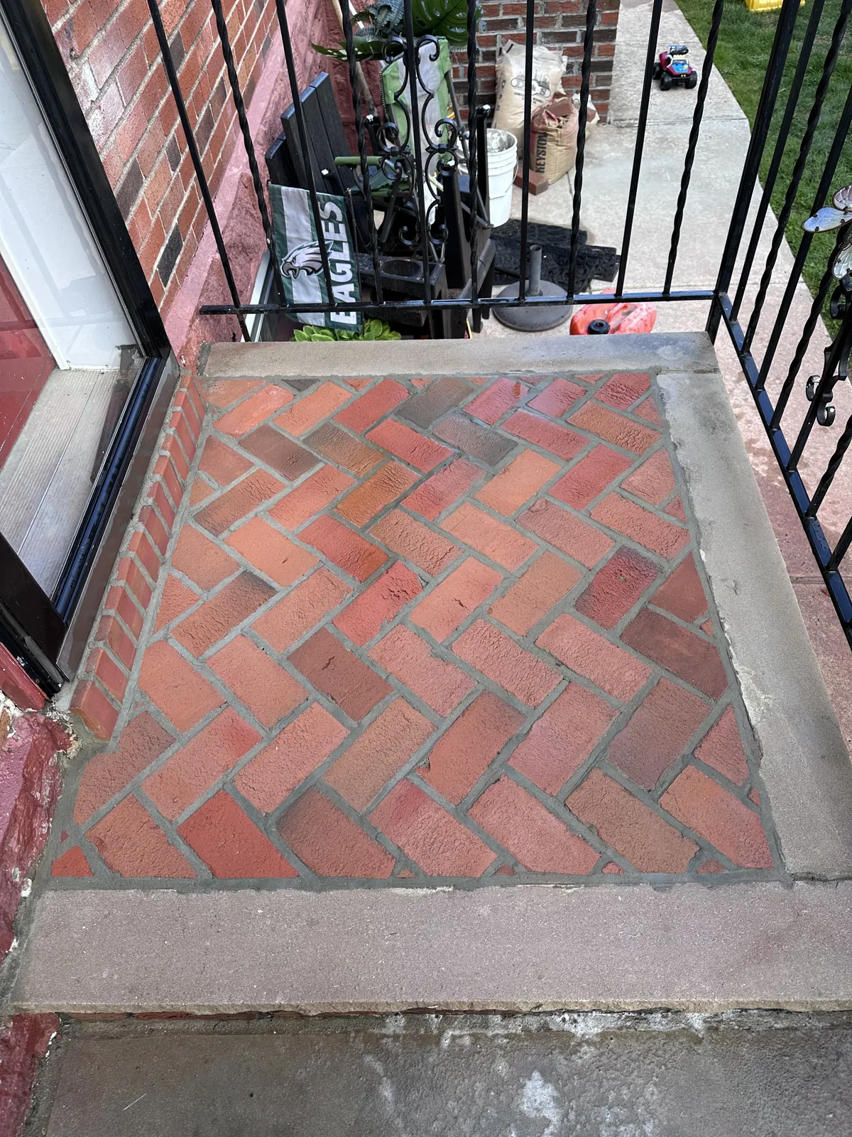 After: Stoop rebuilt with a herringbone brick inlay inside a concrete border
